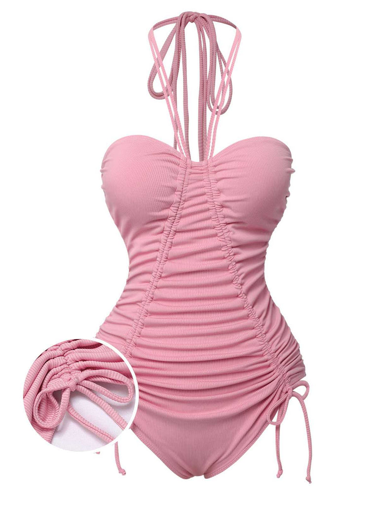 She's wearing Pink 1950s Halter Pleated Solid One-Piece Swimsuit and the whole beach remembers the 1950s