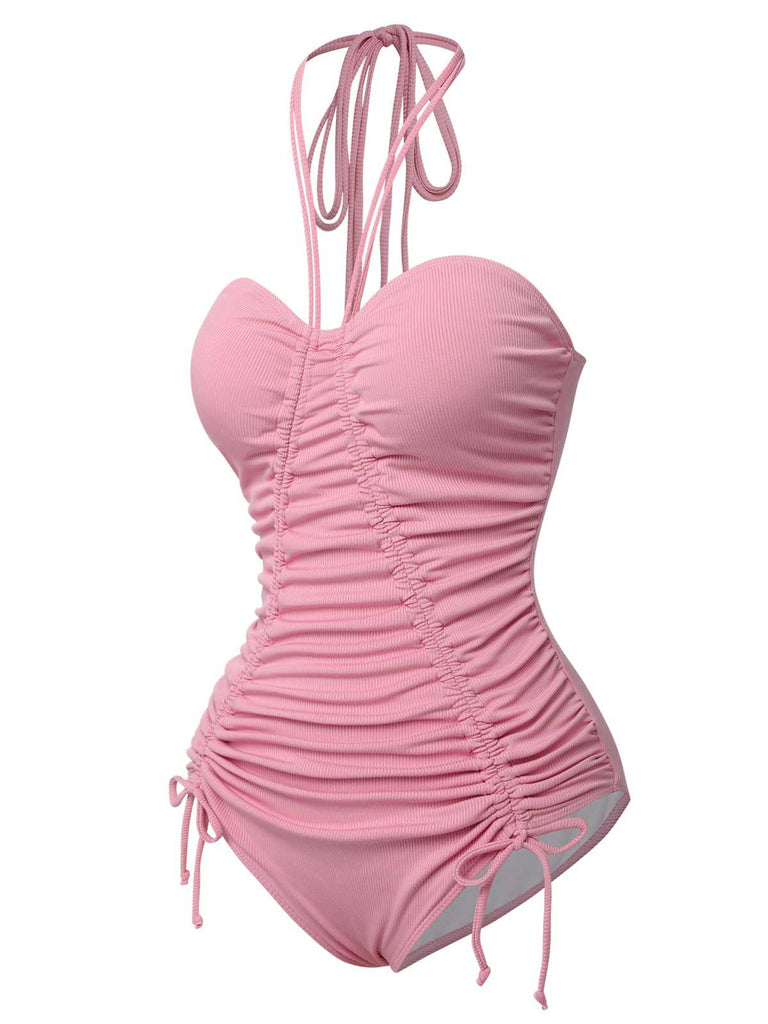 This Pink 1950s Halter Pleated Solid One-Piece Swimsuit carries 1950s vacation dreams in every stitch